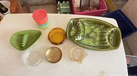 All items on tabletop: two green ceramic ashtrays, amber glass ashtray, two small glass dishes, stack of neon plastic cups
