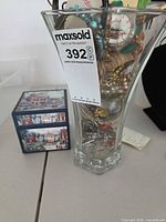Overall lot showing glass vase filled with jewelry and watch