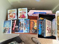 All items laid out: two Flintstones slipcases, five individual movie DVDs, open storage box with Andy Griffith Show and Magnum P.I. sets