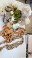 Group shot showing all yarn balls, jute twine cones and macramé hangers on table