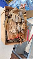 Box filled with numerous worn leather/canvas work gloves in assorted styles and sizes
