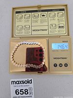 Bracelet on digital scale showing 14.64 g