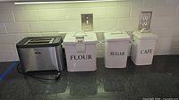 Toaster and three canisters on countertop