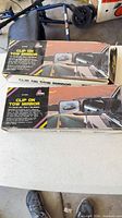 Two boxed Prime Products clip-on tow mirrors on table