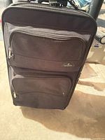 Front view showing overall suitcase, color, pockets, zippers, brand logo