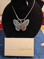 Full view of butterfly pendant on chain with box