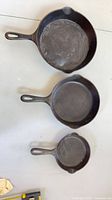 Three cast iron skillets top view showing interior condition and relative sizes