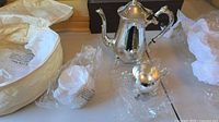 Full view of coffee pot, creamer, and sugar bowl lid wrapped, showing style and finish