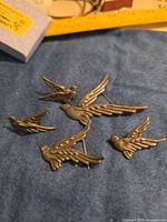 Five sterling silver bird pins on fabric background