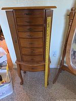 Front view of jewelry armoire with ruler indicating 36 in. height