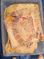 Quilt folded in tote showing patched Dresden plate sections with frayed edges