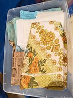 Bin containing assorted fabric pieces, yellow-green floral yardage visible