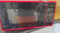 Front view of red Walmart microwave showing door, control panel and digital display
