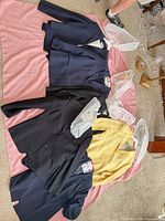 Six blazers laid out on pink cloth showing colors and styles