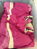 Pink hooded jacket folded in storage bin