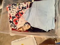 Tote containing floral print, beige ribbed, light blue and purple knit tops