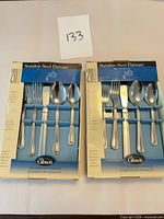 Front view of two boxed Gibson 20-piece stainless steel flatware sets