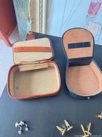 Open brown/tan and black jewelry boxes with several cufflink pairs nearby