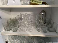 Shelf showing wine goblets, rocks tumblers, shot/lowball glasses