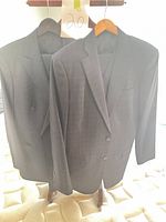 Two charcoal windowpane jackets on hangers