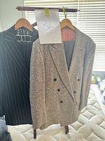 Both jackets hanging: tweed blazer right, pinstripe blazer left, size tag 36 visible