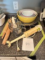 Overall lot with bowls, immersion blender, measuring cups, rolling pins, metal pans and spoons