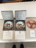 Two plates in foam cases with certificates visible