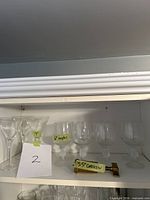 Shelf view of martini glasses, goblet glasses and brass corkscrew