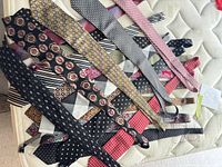 Group of 14 silk neckties laid out showing variety of patterns and colours