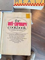 Cover of The Anti-Coronary Cookbook with sticker residue