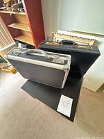 Both briefcases side by side on table showing overall sizes and materials