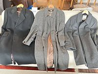 Front view of all three overcoats on hangers