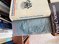 Stack of hardcovers showing dust jackets of A Very Personal Presidency and American Government plus other spines