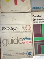 Expo 67 Official Guide and adjacent paperbacks showing titles and wear