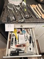 Countertop grouping of stainless and wooden cooking utensils