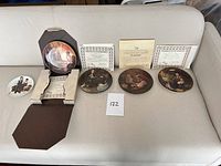 Overview of five plates, boxes, certificates on couch