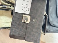 Close-up of brown patterned briefcase showing metal combination lock