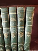 Spines of four Harvard Classics volumes showing gilt crest and titles Tennyson to Whitman, American Historical Documents, Marlowe Shakespeare, Masterplots 1972 Annual Magill