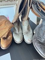 Front view of all three boot pairs showing colors and wear