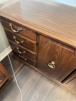 Left section showing four drawers with brass bail pulls beside a paneled door