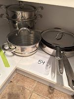 Group view of stacked stockpot with insert, saucepan with insert, sauté pan with lid