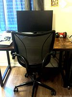 Rear view of black mesh office chair at desk