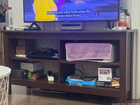 Front view of espresso TV stand showing six open cubbies and top surface under TV