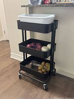 Cart in home setting showing three shelves with casters attached
