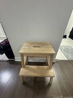 Front view of two-step natural finish stool showing overall design