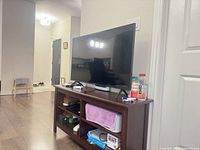 TV on media console angled view with cords and juice bottle