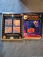 Two boxed Halloween light sets side by side