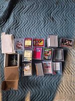 Overview of boxed and sleeved trading cards in plastic bricks on quilted surface