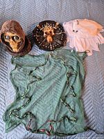 All four Halloween items laid out: animatronic skull, skull plaque, ghost sheet, lighted net