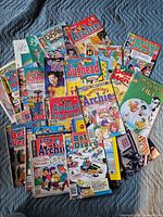 Spread of entire lot of comic books on quilt, showing mix of Archie and Harvey titles